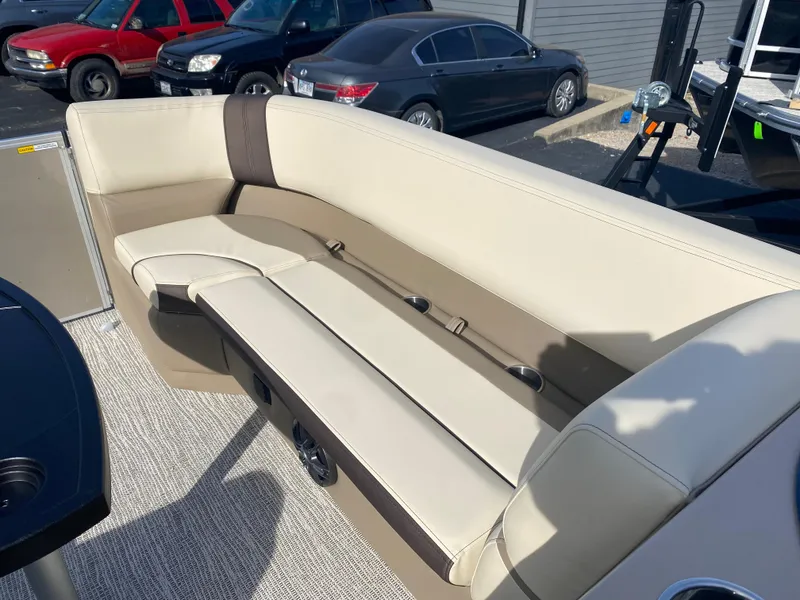 Slide: The Image of 2025 SunCatcher Select 322RC boat interior with beige seating and cup holders. - 14