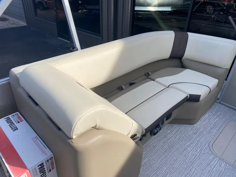 Slide: The Image of 2025 SunCatcher Select 322RC boat interior seating with beige upholstery. - 15