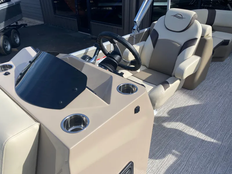 Slide: The Image of 2025 SunCatcher Select 322RC boat interior with steering wheel and comfortable seating. - 18