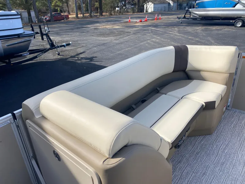 Slide: The Image of 2025 SunCatcher Select 322RC boat interior with beige seating in a parking lot. - 19
