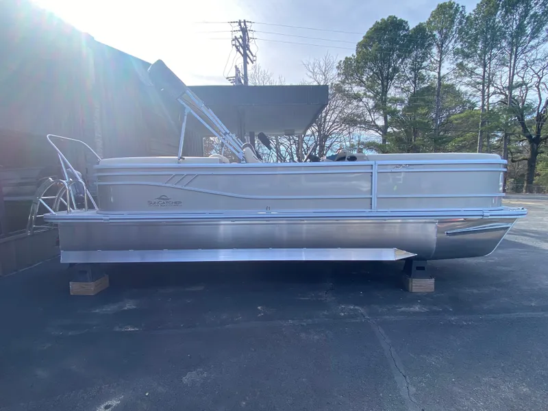 Slide: The Image of 2025 SunCatcher Select 322RC pontoon boat on display outdoors. - 2