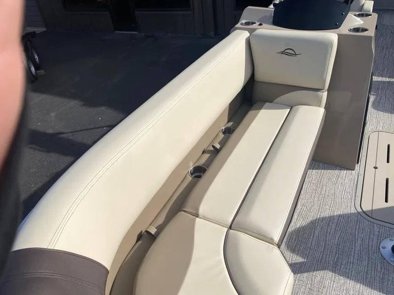 Slide: The Image of 2025 SunCatcher Select 322RC boat interior with beige seating and cup holders. - 23