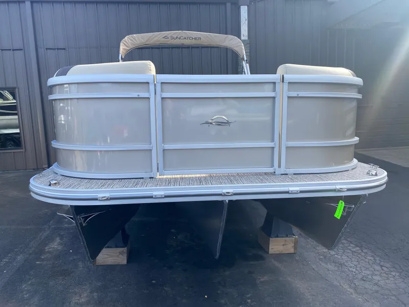 Slide: The Image of 2025 SunCatcher Select 322RC pontoon boat, front view, parked on blocks. - 4