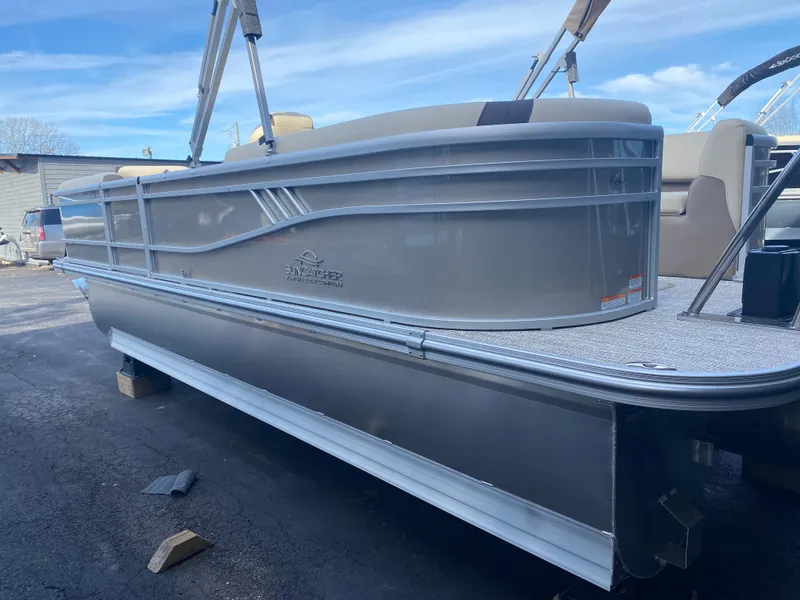 Slide: The Image of 2025 SunCatcher Select 322RC pontoon boat, silver exterior, docked on land. - 6