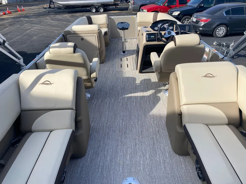 Slide: The Image of 2025 SunCatcher Select 322RC pontoon boat interior with beige seating and steering console. - 9