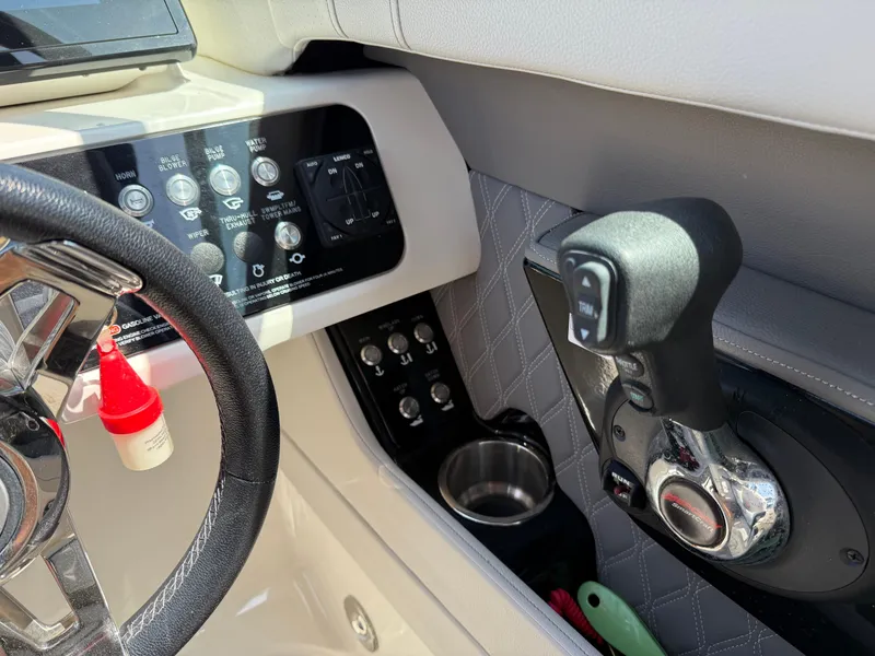 Slide: The Image of Control panel and steering of 2022 Sea Ray SLX 280 boat, featuring modern controls and cup holder. - 29