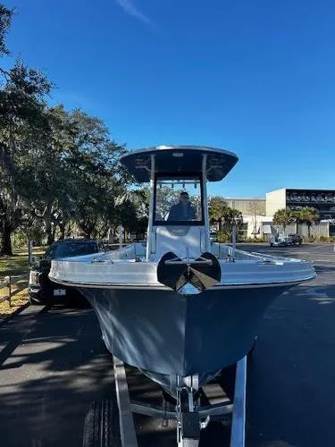 Slide: The Image of 2024 Parker 2400 Center Console boat on trailer, parked outdoors under clear blue sky. - 2