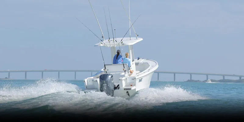 Slide: The Image of 2024 Parker 2400 Center Console boat cruising on open water with bridge in background. - 21