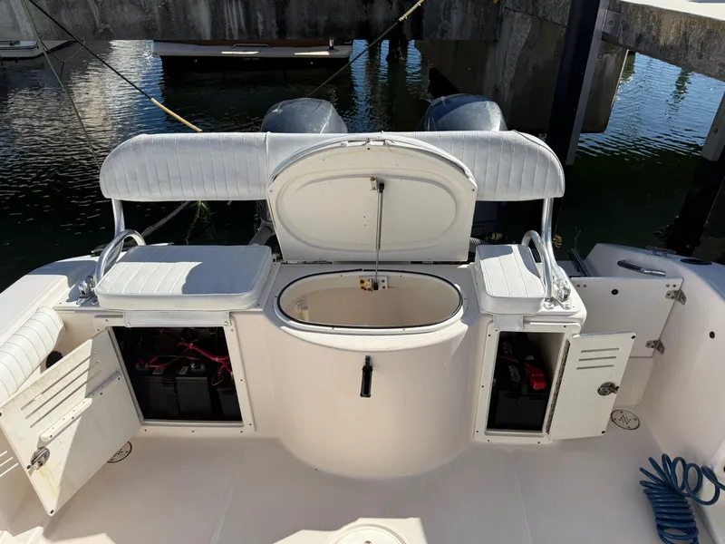 Slide: The Image of 2006 Cobia 250 Walk-Around boat interior with open storage compartments and seating. - 19