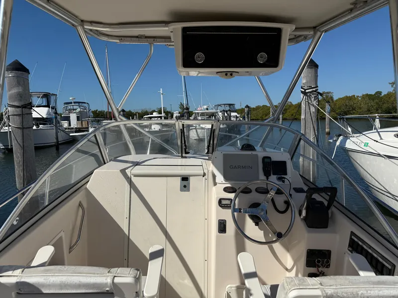 Slide: The Image of 2006 Cobia 250 Walk-Around boat interior with steering wheel and navigation equipment. - 7