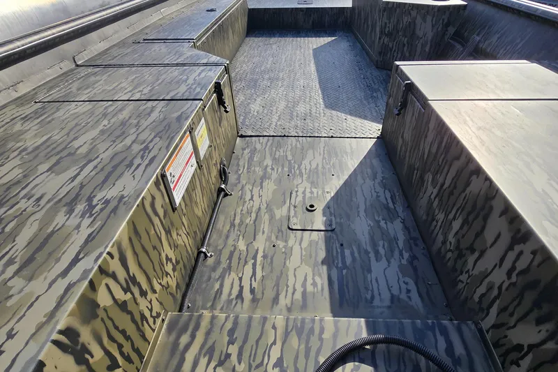 Slide: The Image of 2025 SeaArk DXS 1860 SLD boat interior with camouflage design and storage compartments. - 2