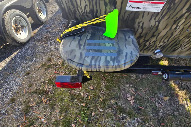 Slide: The Image of 2025 SeaArk DXS 1860 SLD boat trailer with camouflage pattern and safety features. - 4