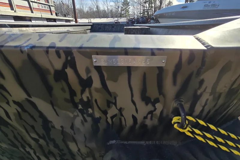 Slide: The Image of 2025 SeaArk DXS 1860 SLD boat with camouflage pattern and yellow rope detail. - 6