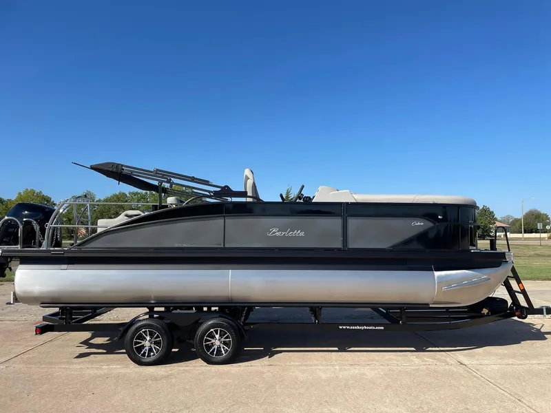 Slide: The Image of 2024 Barletta Cabrio 22UC pontoon boat on trailer, side view, clear sky background. - 14