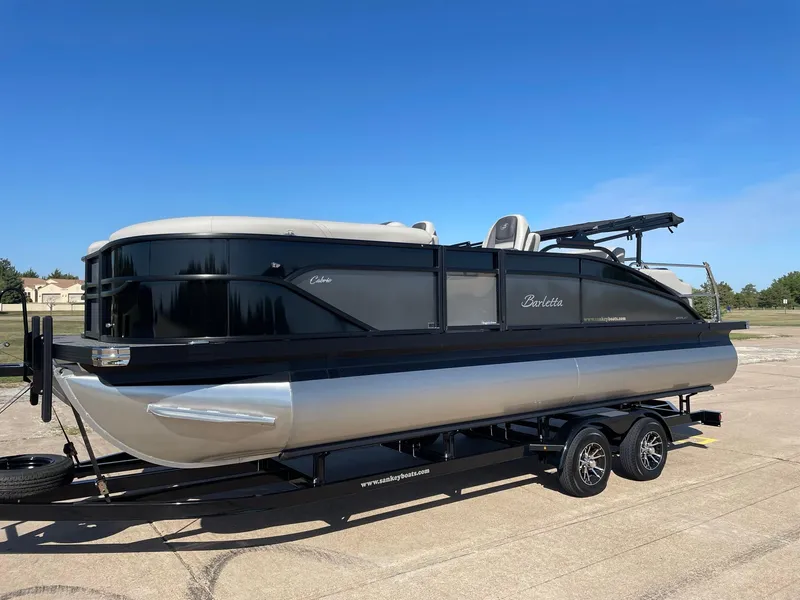 Slide: The Image of 2024 Barletta Cabrio 22UC pontoon boat on trailer, sleek design, black and silver finish. - 3