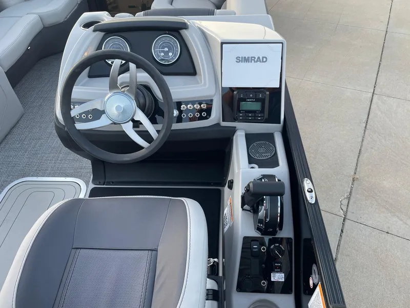 Slide: The Image of 2024 Barletta Cabrio 22UC boat dashboard with steering wheel and Simrad display. - 36