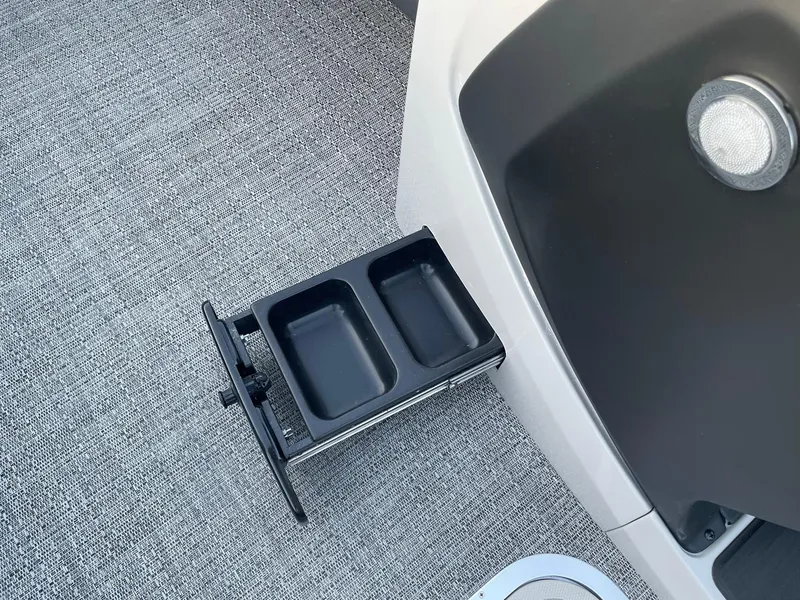 Slide: The Image of 2024 Barletta Cabrio 22UC boat interior with dual cup holder on gray carpet. - 39