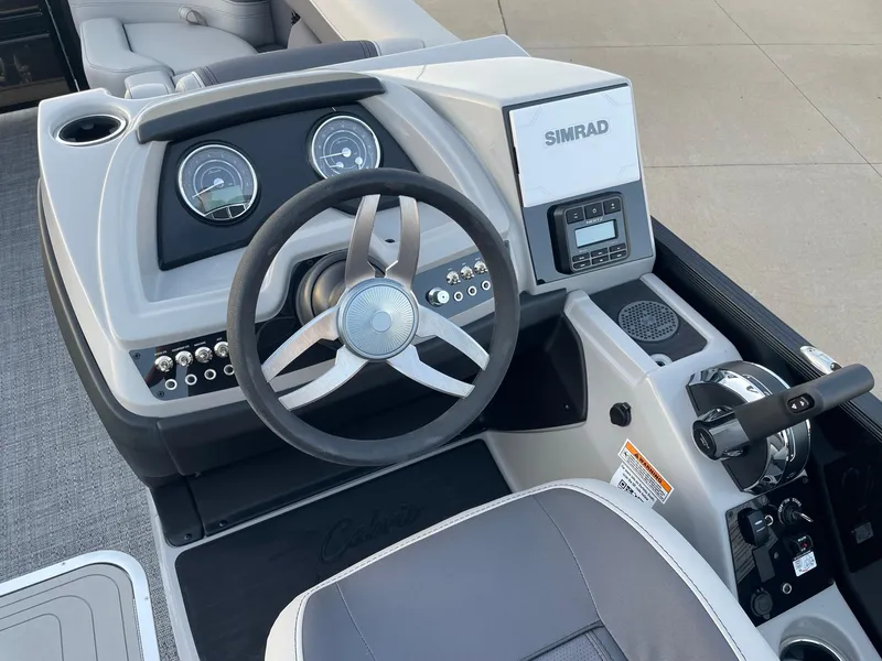 Slide: The Image of 2024 Barletta Cabrio 22UC boat dashboard with steering wheel and Simrad display. - 41