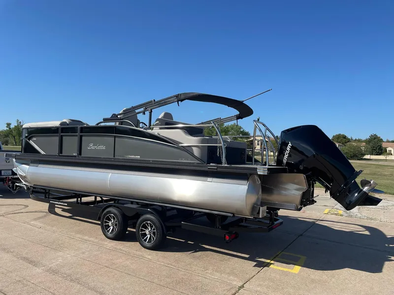 Slide: The Image of 2024 Barletta Cabrio 22UC pontoon boat on trailer, parked outdoors. - 6