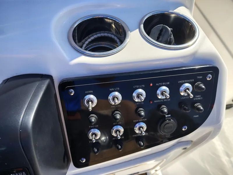 Slide: The Image of Control panel of 2024 NauticStar 211 Hybrid boat with cup holders. - 10