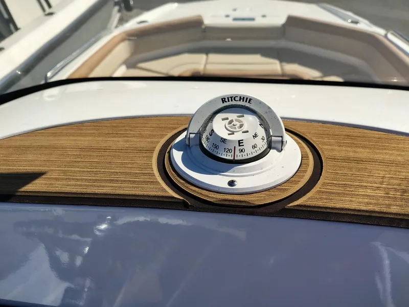 Slide: The Image of 2024 NauticStar 211 Hybrid boat with Ritchie compass on wooden dashboard. - 11