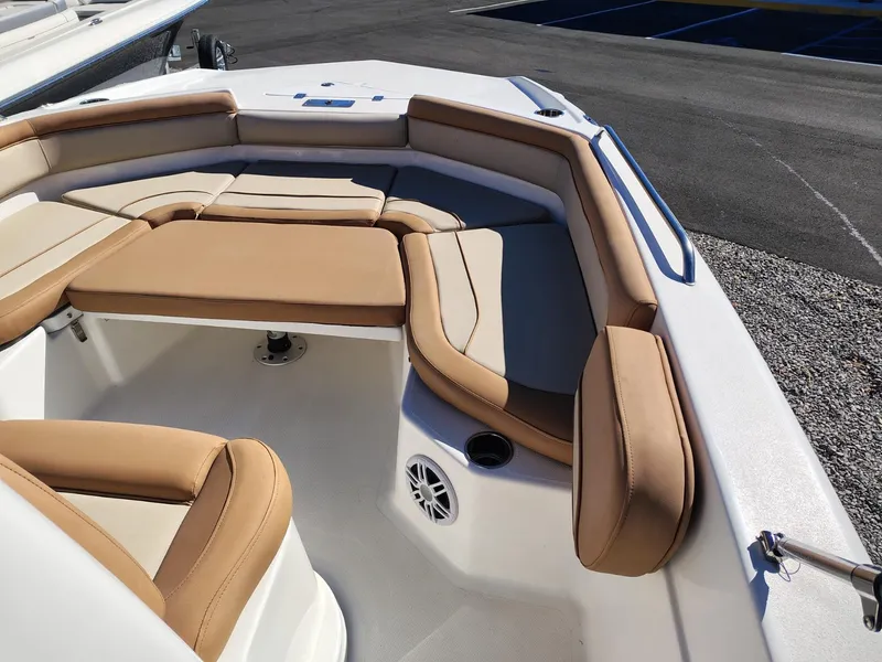 Slide: The Image of 2024 NauticStar 211 Hybrid boat interior with tan cushioned seating and speaker. - 5