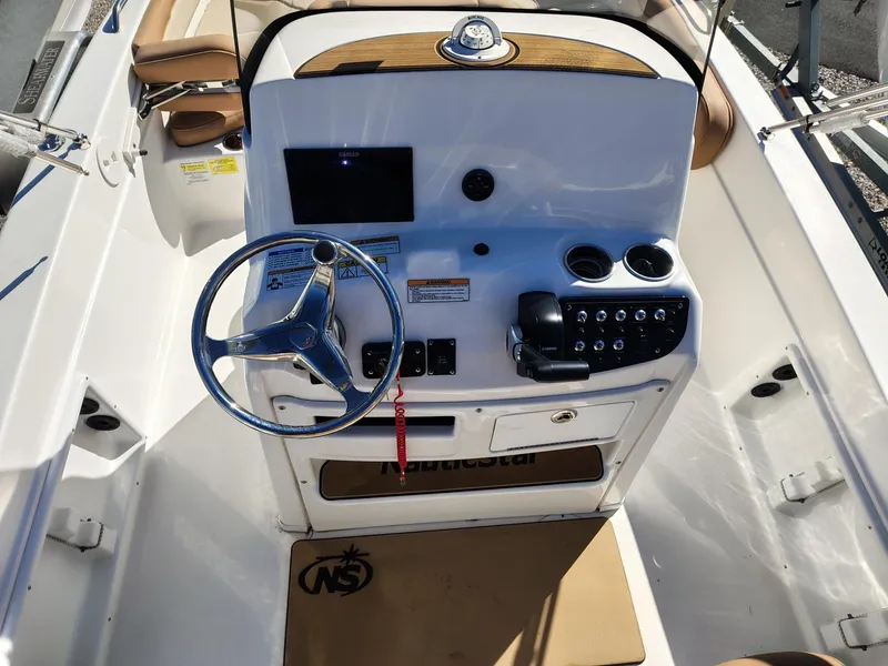 Slide: The Image of 2024 NauticStar 211 Hybrid boat console with steering wheel and control panel. - 8