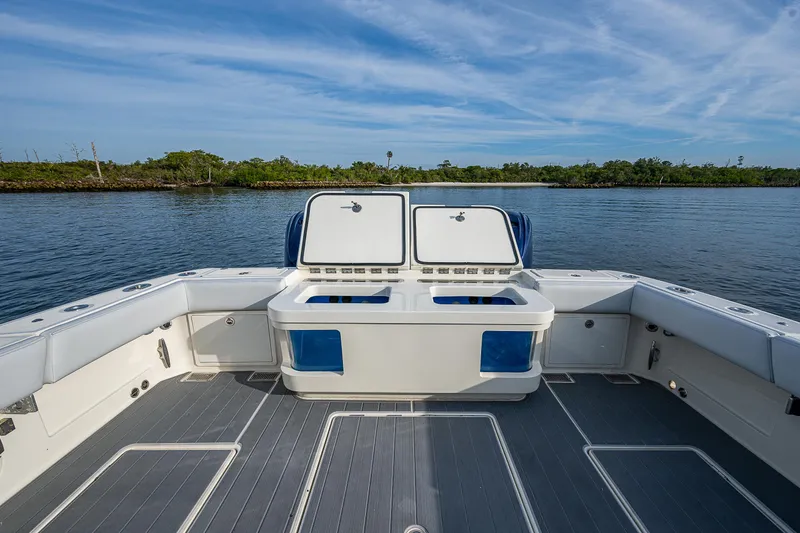 Slide: The Image of 2017 HCB 53 boat deck with open storage compartments, on calm water. - 11