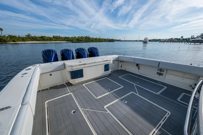 Slide: The Image of 2017 HCB 53 boat deck with four engines, on calm water under a blue sky. - 12