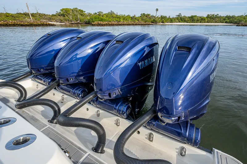 Slide: The Image of Four Yamaha outboard motors on a 2017 HCB 53 boat, docked in a scenic waterway. - 14