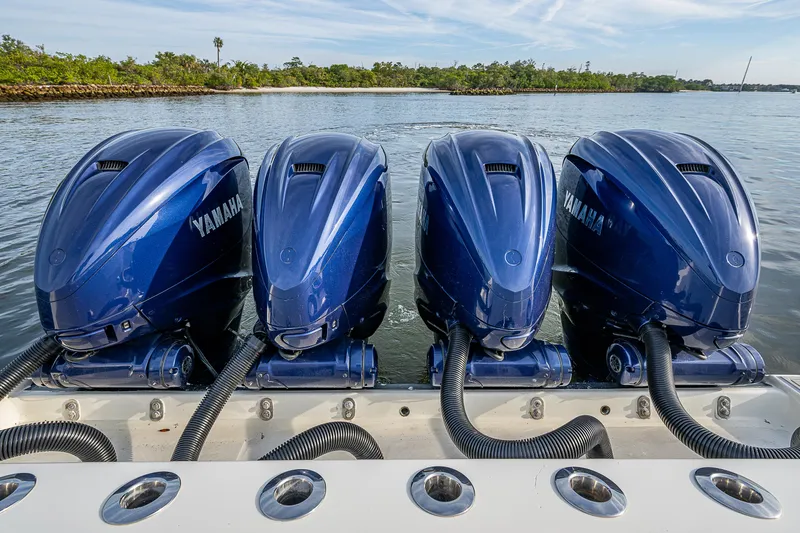 Slide: The Image of Four Yamaha outboard engines on a 2017 HCB 53 boat, docked on calm water. - 15
