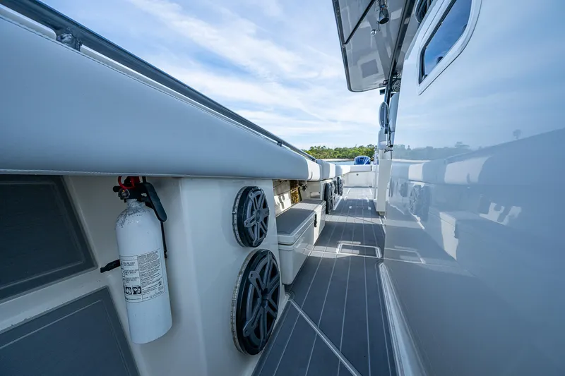 Slide: The Image of 2017 HCB 53 boat deck with speakers and fire extinguisher, under a clear sky. - 18