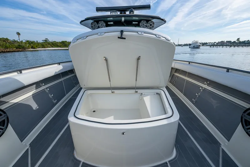 Slide: The Image of 2017 HCB 53 boat with open storage compartment on deck, near water. - 21