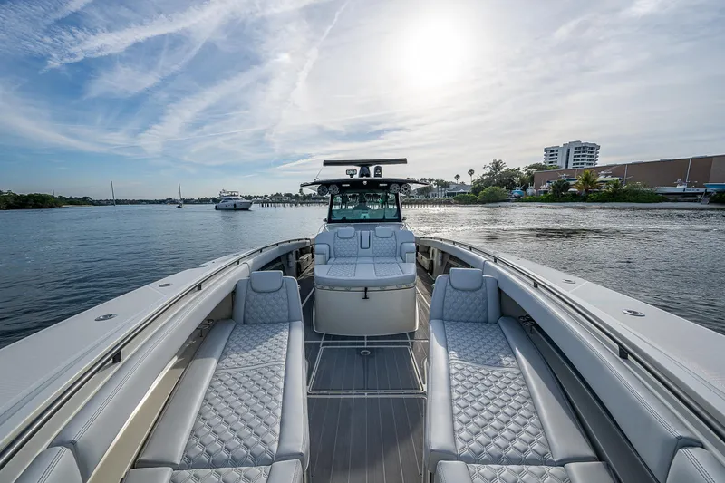 Slide: The Image of Luxury 2017 HCB 53 boat with elegant seating on calm water under a bright sky. - 23