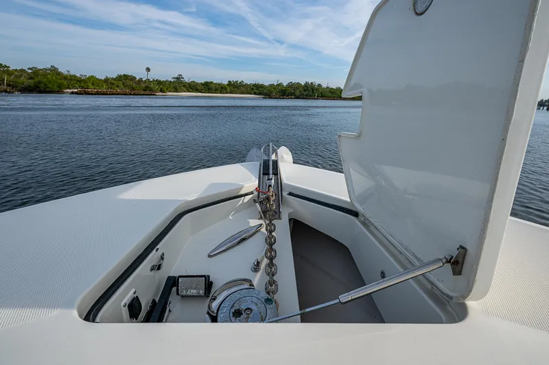Slide: The Image of 2017 HCB 53 boat anchor compartment with open hatch on calm water. - 24