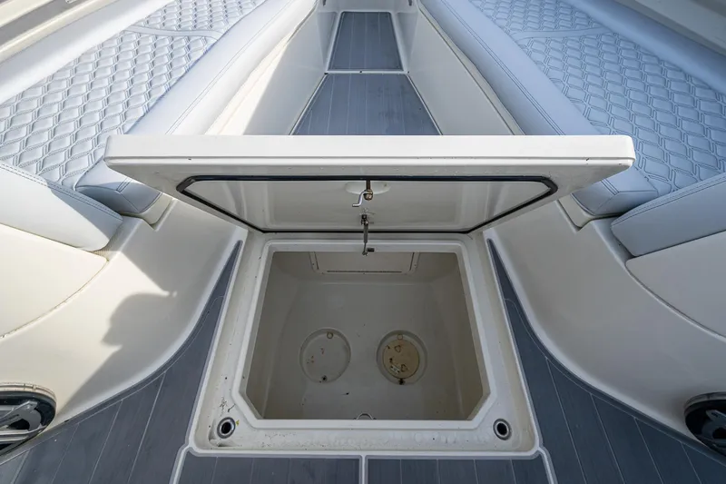Slide: The Image of Open storage compartment on 2017 HCB 53 boat with cushioned seating. - 25