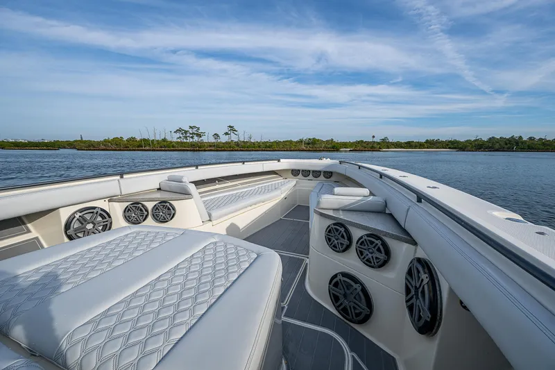 Slide: The Image of 2017 HCB 53 boat interior with luxurious seating and speakers on a calm water backdrop. - 28