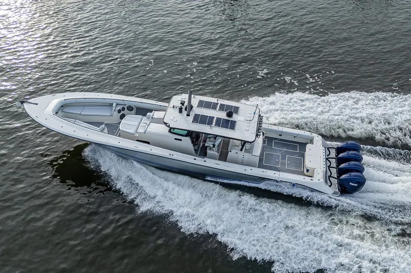 Slide: The Image of HCB 53 boat from 2017 cruising on water with four outboard engines. - 33