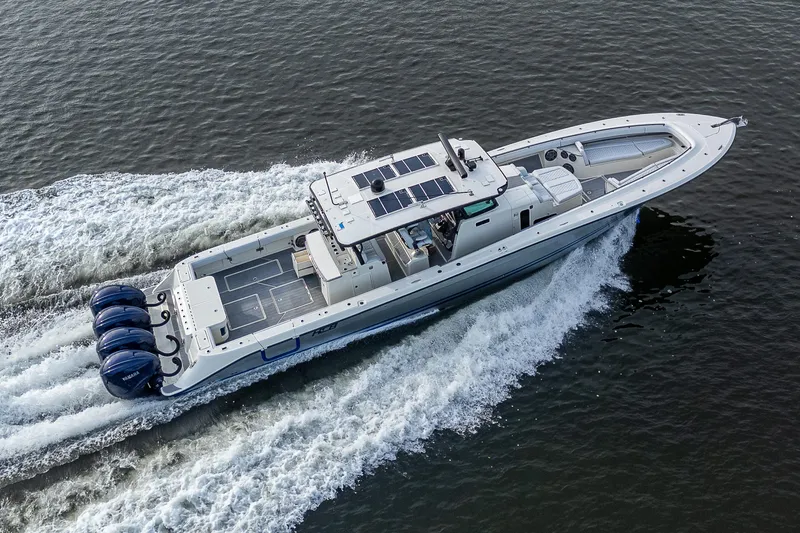 Slide: The Image of 2017 HCB 53 boat cruising on water with four powerful outboard engines. - 45