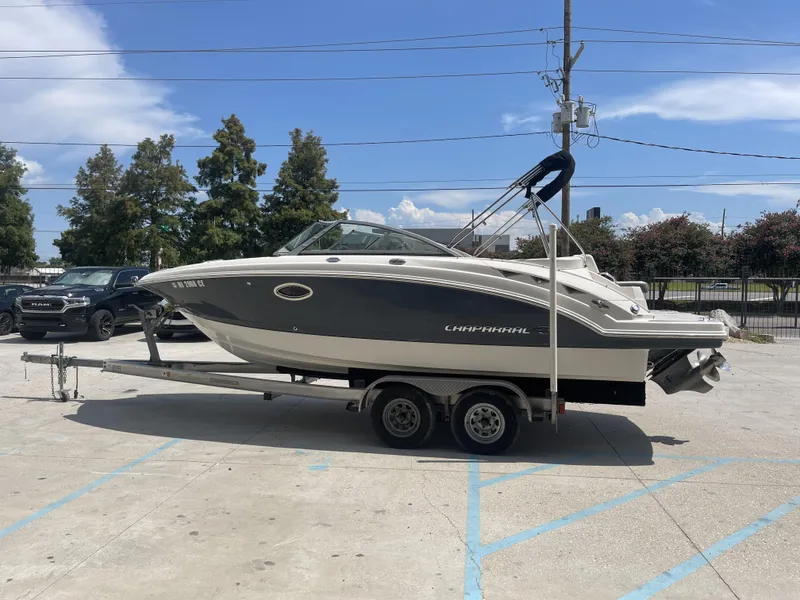 Slide: The Image of 2014 Chaparral Sunesta 224 boat on trailer, parked under a canopy with an American flag. - 20