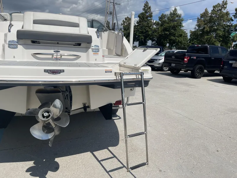 Slide: The Image of 2014 Chaparral Sunesta 224 boat interior with steering wheel and dashboard, parked outdoors. - 23