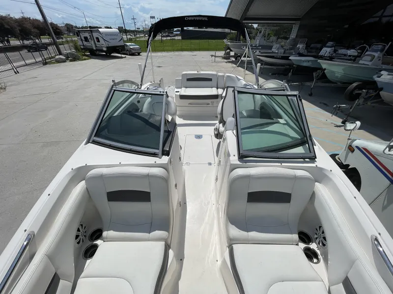 Slide: The Image of 2014 Chaparral Sunesta 224 boat interior with white seating and speaker. - 25