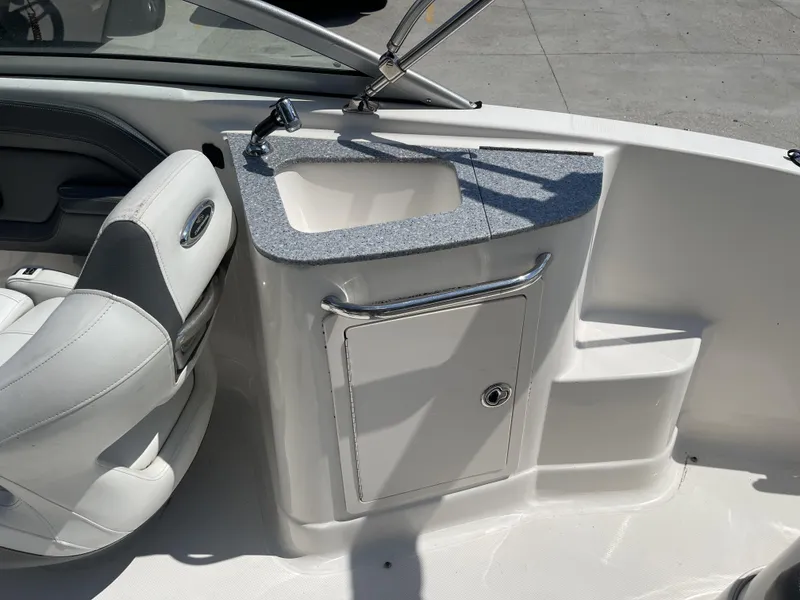 Slide: The Image of 2014 Chaparral Sunesta 224 boat interior with steering wheel and sink. - 28