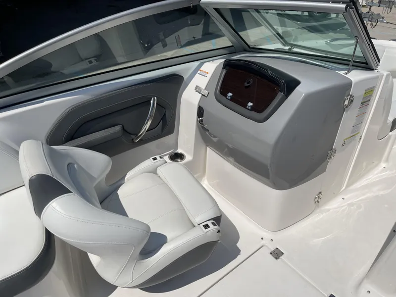 Slide: The Image of 2014 Chaparral Sunesta 224 boat seating with cup holder, featuring white and black upholstery. - 31