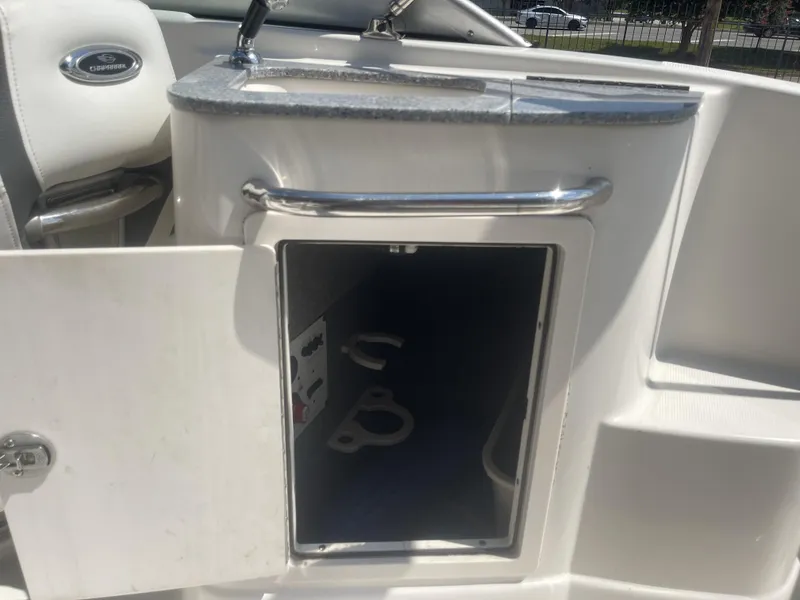 Slide: The Image of 2014 Chaparral Sunesta 224 boat console with storage compartment and stereo system. - 34