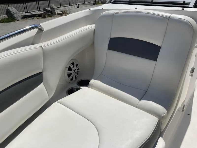 Slide: The Image of 2014 Chaparral Sunesta 224 boat interior with white seating, parked in a lot. - 7
