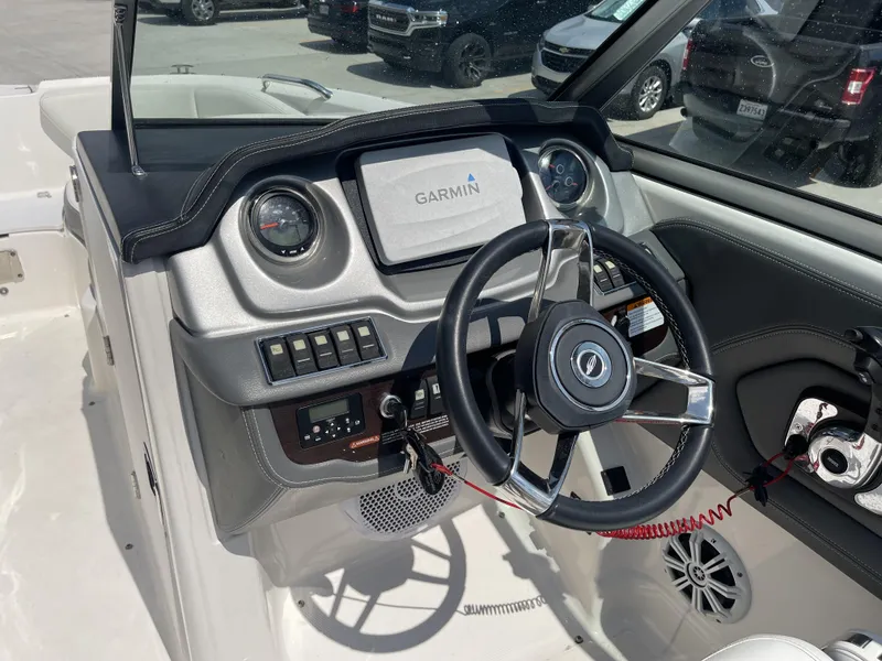 Slide: The Image of 2014 Chaparral Sunesta 224 boat interior with seating and storage, parked in a lot. - 8