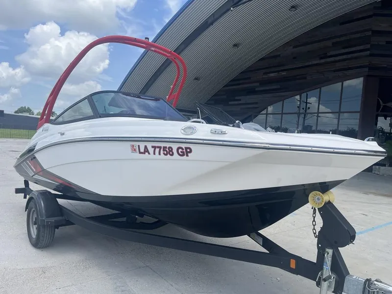 Slide: The Image of 2018 Yamaha Boats AR195 on trailer, white hull, red wakeboard tower, parked outdoors. - 3