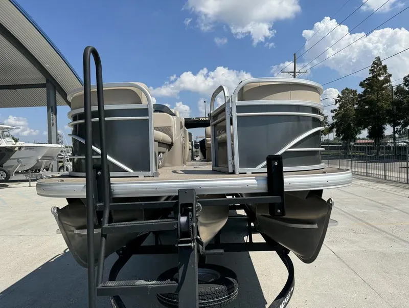 Slide: The Image of 2023 Sun Tracker Party Barge 22 DLX pontoon boat on trailer, sunny day. - 10