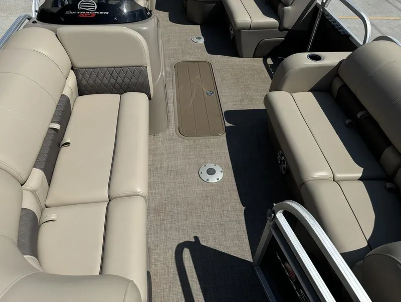 Slide: The Image of 2023 Sun Tracker Party Barge 22 DLX interior with beige seating and spacious layout. - 12